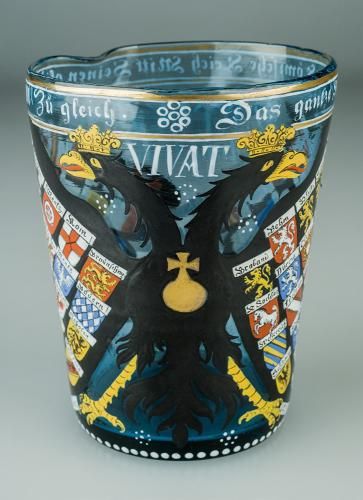 Reichsadlerglas mit Inschrift: Das gantze Heilige Römische Reich Mitt Seinen gliedern All Zu gleich // VIVAT // G.W.M Z B // Anno 1616“ Bläuliches Glas, geblasen, mit Emailfarben bemalt; H. 13,5 cm, Dm. 10,5 cm (Foto: KMH) Reichsadlerglas mit Inschrift: Das gantze Heilige Römische Reich Mitt Seinen gliedern All Zu gleich // VIVAT // G.W.M Z B // Anno 1616“ Bläuliches Glas, geblasen, mit Emailfarben bemalt; H. 13,5 cm, Dm. 10,5 cm (Foto: KMH)